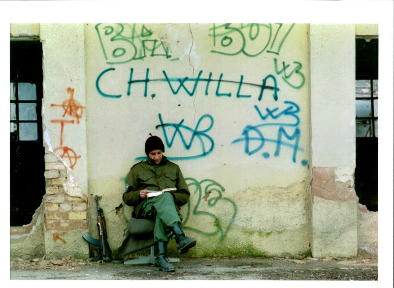 A bosnian soldier reads a book. - Vintage Photograph