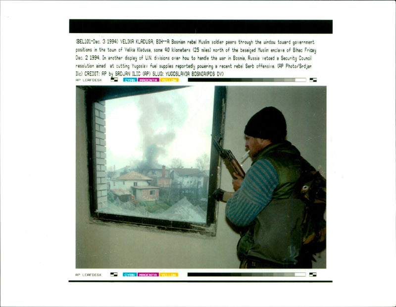 A Bosnian rebel muslim soldier peers through window. - Vintage Photograph