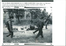 Serb soldiers run as they carry a stretcher. - Vintage Photograph