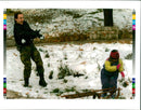 1995 BOSNIAN ARMY SOLDIER PLAYS THE SNOW WITH HIS DAUGHTER WRITER CAPITAL - Vintage Photograph