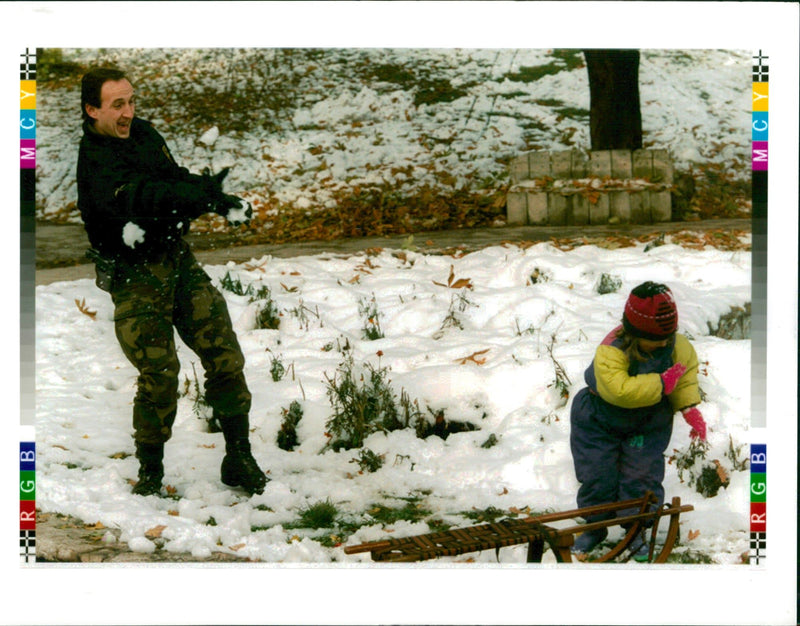 1995 BOSNIAN ARMY SOLDIER PLAYS THE SNOW WITH HIS DAUGHTER WRITER CAPITAL - Vintage Photograph