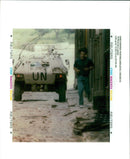 A young man runs through a rubble filled street. - Vintage Photograph