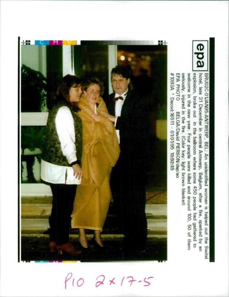 An unidentified woman is helped out the Switel Hotel. - Vintage Photograph