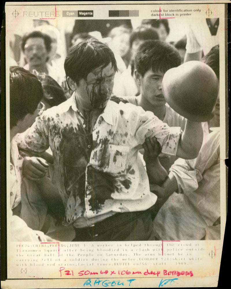 Soaked in blood a worker is helped through the crowd in Tiananmen Square. - Vintage Photograph