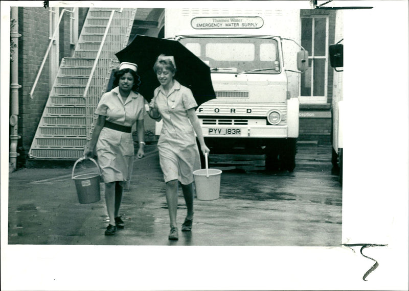 Nurses collecting water from an emergency tanker. - Vintage Photograph