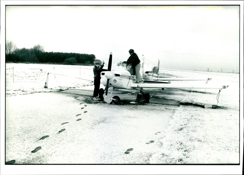 Pilots clearing snow from the planes at Elstree Aerodrome - Vintage Photograph