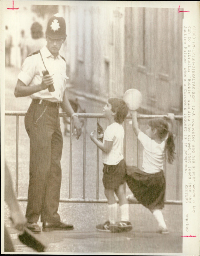 A youngster and his sister waves a toy gun - Vintage Photograph