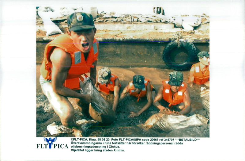 Floods continue in China. Rescue personnel are trying to rescue the oil drilling equipment in Xinhua. - Vintage Photograph