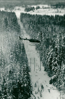 Vattenfall in Sweden has hired helicopters to ride along the power lines and blow down the snow. - Vintage Photograph