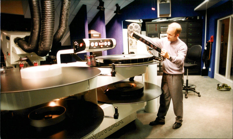 A Man  Handling a Huge Film Roll at the Cosmonova - Vintage Photograph