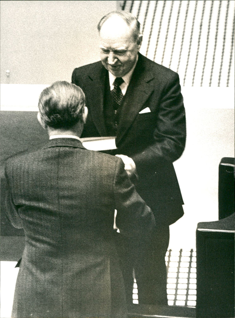 Minister of Justice Romaus hands over his speech to Speaker Henry Allard during Parliament 1977. - Vintage Photograph