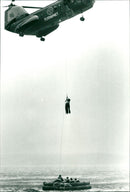 Lifeguard exercise with Ilamatar Liisa Kepynen and Marjatta Valo raised in rescue helicopter. - Vintage Photograph