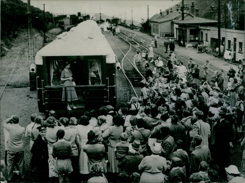 Queen Elizabeth II Royal tour of New Zealand. The Royal train pulls into Cross Creek and the Queen is greeted by the entire population while standing on the observation platform - Vintage Photograph