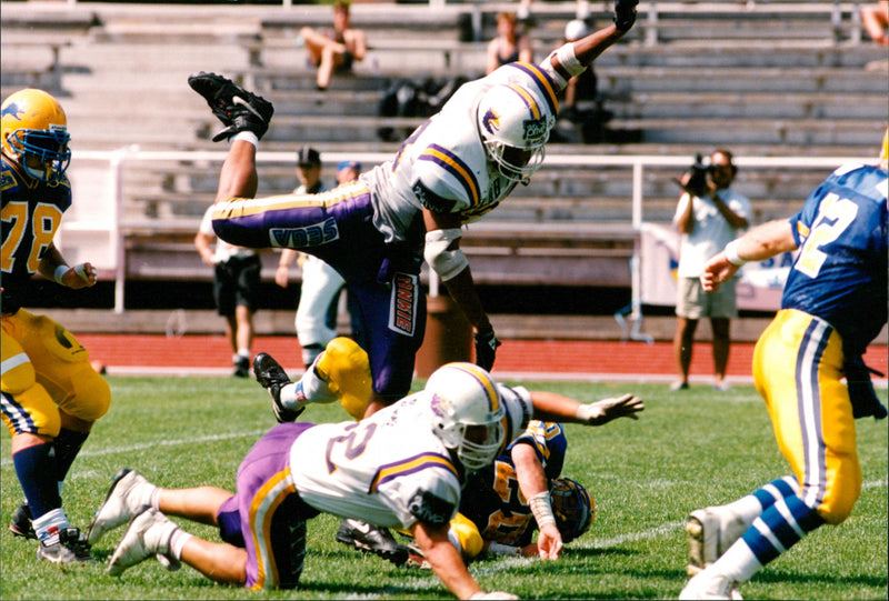 SM final in American football at Stockholm Stadium. 22-year-old running back Fredrik Nanhed  on his knees closest to the camera. - Vintage Photograph