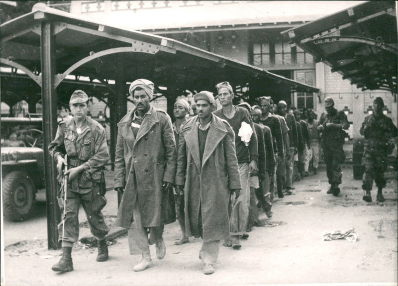 Egyptian soldiers taken captive by French troops are taken to a prison camp. - Vintage Photograph