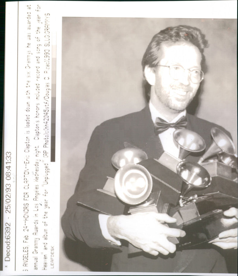 Eric Clapton is loaded with the six Grammys he was awarded at annual Grammy Awards in Los Angeles. - Vintage Photograph