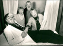 Gunilla Akesson, John Harryson and Inga Gill take the temperature of play writer Olov Svedelid. - Vintage Photograph