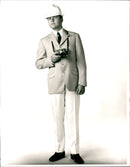 Male Model in a High buttoned blazer and off-white Pants of 1960 Men's Fashion Spring Collection - Vintage Photograph