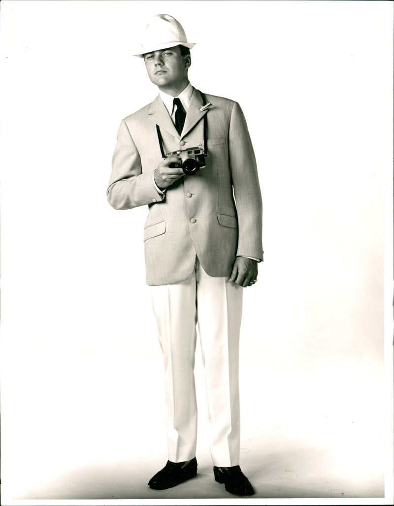 Male Model in a High buttoned blazer and off-white Pants of 1960 Men's Fashion Spring Collection - Vintage Photograph