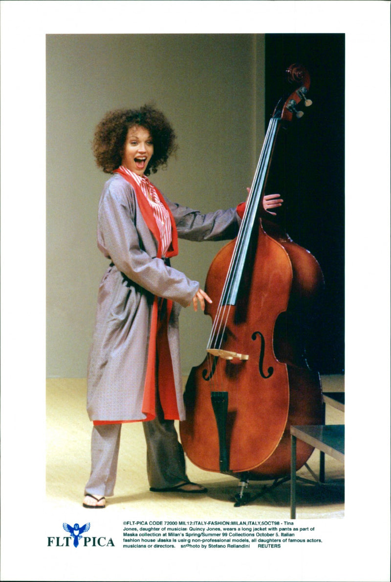 Tina Jones, daughter of musician Quincy Jones, wears a long jacket with pants as part of Maska collection at Milan's Spring Summer 99 Collections. - Vintage Photograph