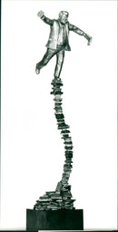 Timo Kärnekull, his writers Eino Hanski presented a sculpture, where the publisher balances on a book stack. - Vintage Photograph