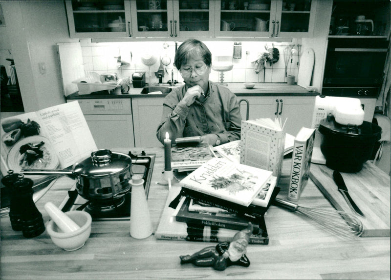Food writer Marianne Sandberg with the notepad in the middle of the stream of Christmas cookbooks - Vintage Photograph