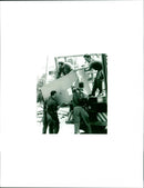 Armed men carrying a filing cabinet to the truck - Vintage Photograph