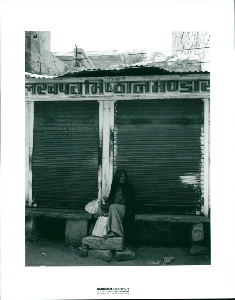 Elderly woman sitting on benach. India - Vintage Photograph