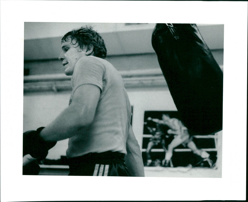 Boxing: A boxer at the gym, boxing bag swinging behind him - Vintage Photograph