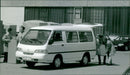 A micro bus and two men loading the trunk - Vintage Photograph