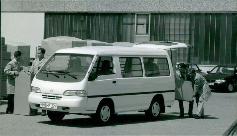 A micro bus and two men loading the trunk - Vintage Photograph