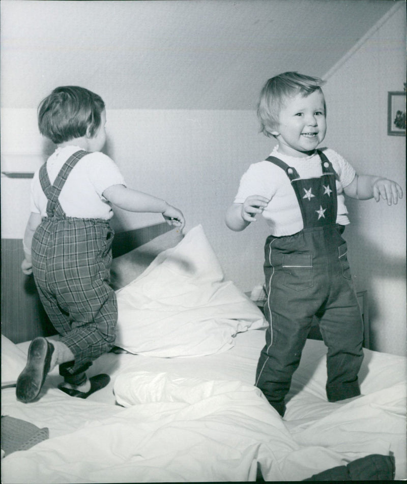 Two happy children are jumping on a bed - Vintage Photograph