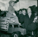 Princess Sibylla holds Prince Carl Gustaf who sits on the model car's lumber yard - Vintage Photograph