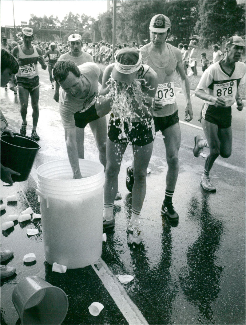 Stockholm Marathon 1982. Maratonlöpare svalkar sig med vatten ur en tunna - Vintage Photograph