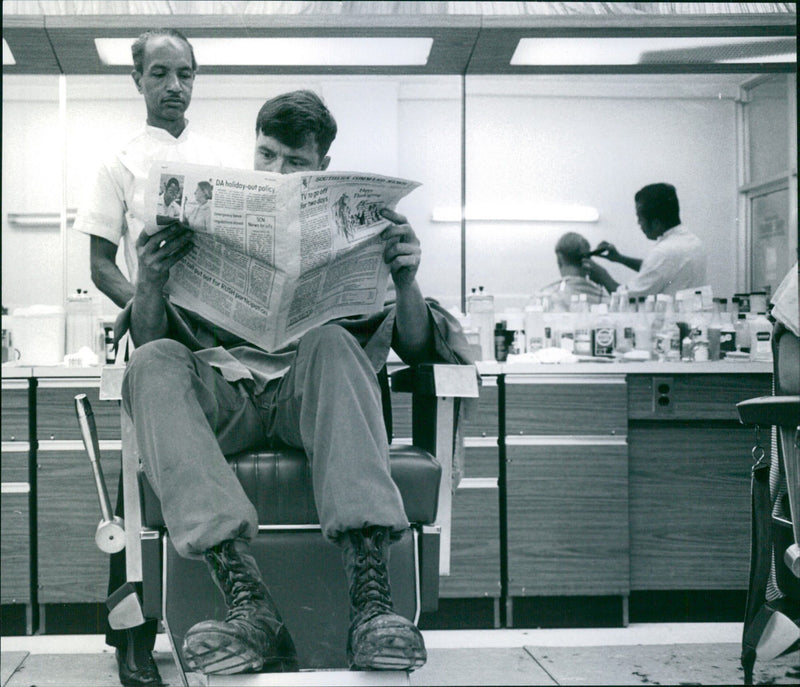 A barber cuts the hair of a US military officer - Vintage Photograph
