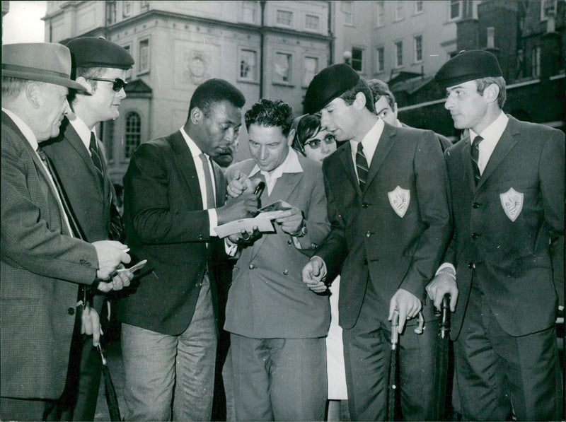 Brazil's soccer star Pelé writes autographs for the French national football team during the 1966 Soccer World Cup - Vintage Photograph