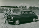 Men and woman in front of a classic car - Vintage Photograph