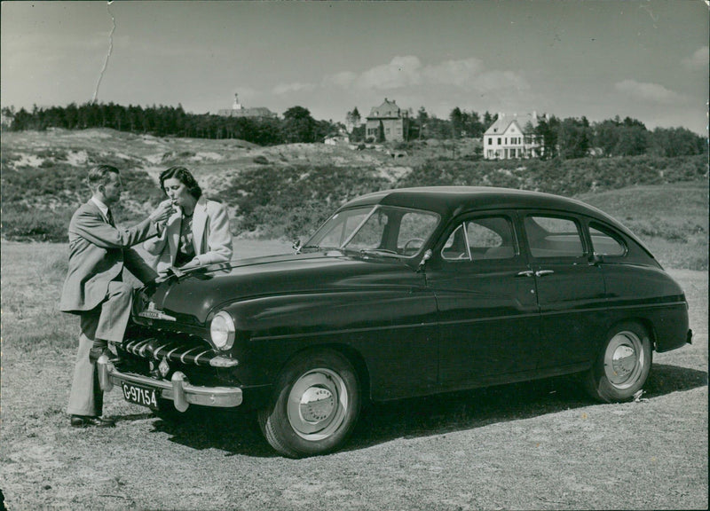 Men and woman in front of a classic car - Vintage Photograph
