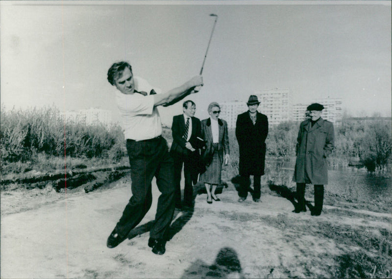 Sven Tumba plays golf in Moscow. Swedish Ambassador Anders Thunborg is seen in the background - Vintage Photograph