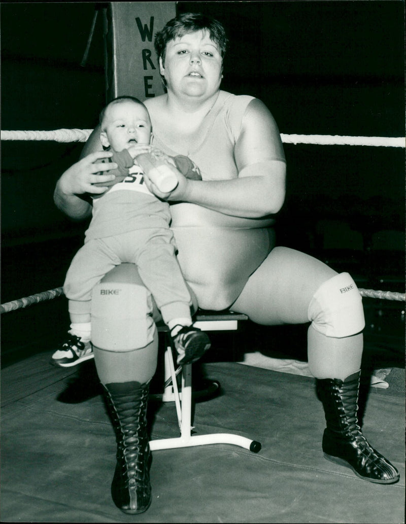 Klondyke Kate, a female wrestler, is pictured with her baby Adam and the baby's father, Ian Dean. She continued to compete while 8 months pregnant and was unaware of her pregnancy. - Vintage Photograph