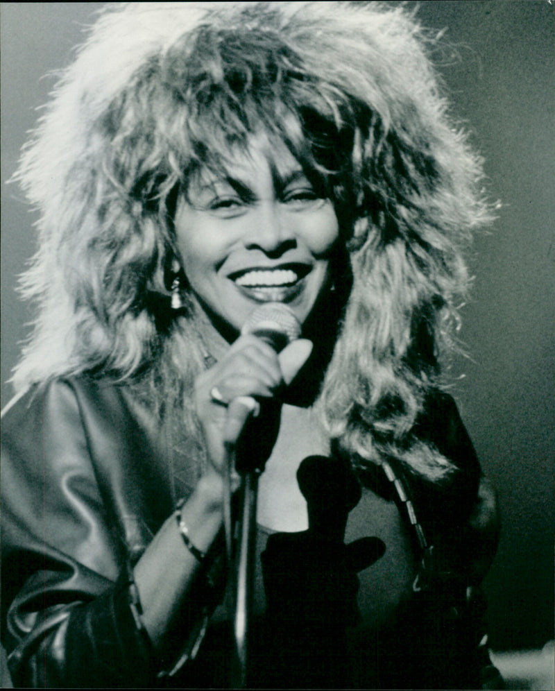 Singer Tina Turner performs in an electrifying concert in London, 1984. - Vintage Photograph