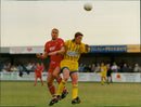 Football players from Castal and This REGAL PEUGEOT IGAL PEUGEOT compete during a match in Witney. - Vintage Photograph