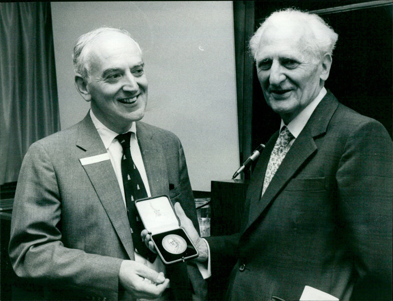 Sir Richard Doll, Professor at Oxford University, receives the prestigious Jenner Award from Professor Walter Holland at the National Radiological Protection Board in Harwell, UK. - Vintage Photograph