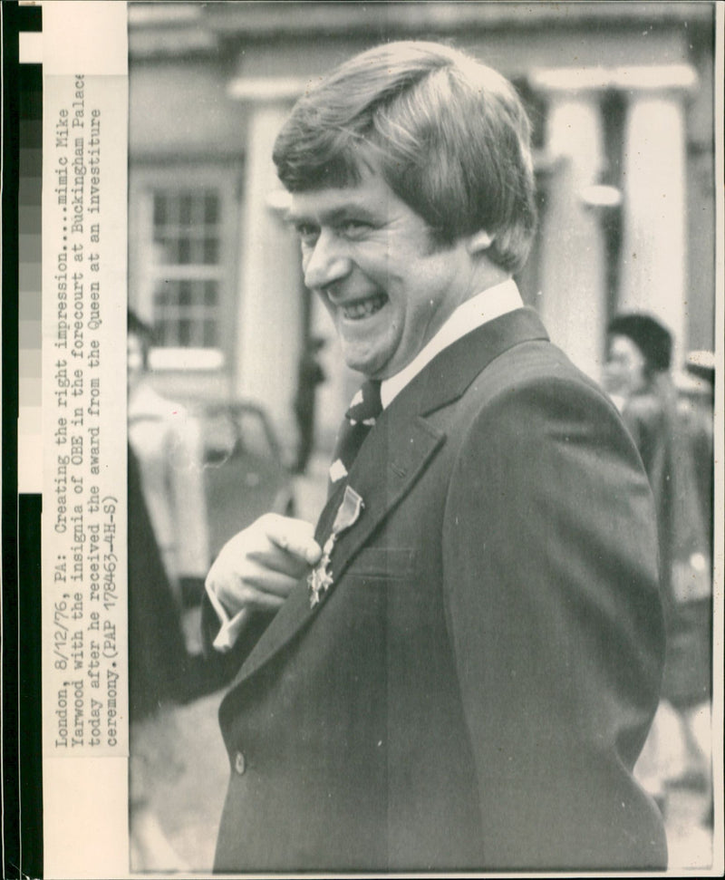 Comedian Mike Yarwood receives the insignia of his OBE from Queen Elizabeth at an investiture ceremony at Buckingham Palace. - Vintage Photograph