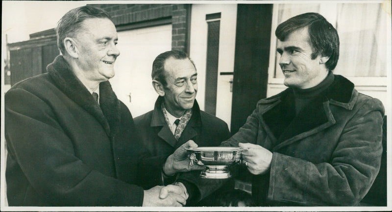 Des Anderson (right) receives a silver rose bowl from mr Eric Smith - Vintage Photograph