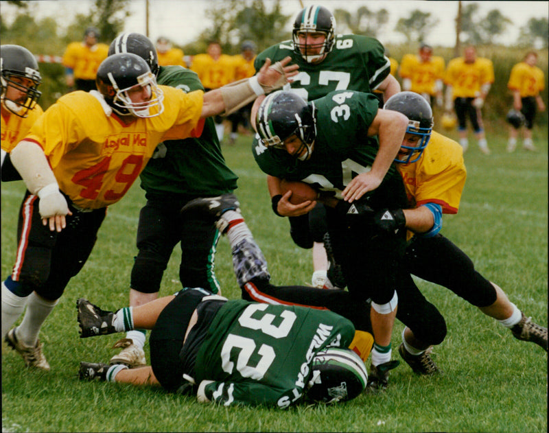 Roger Franklin of the Carterton Wildcats struggles to break free in an American Football match. - Vintage Photograph