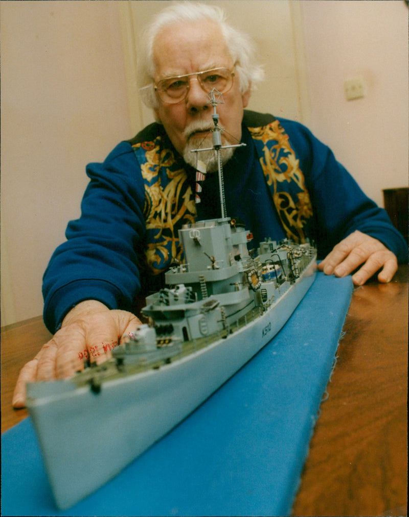 Don Collingwood stands alongside the model of the frigate HMS Cubitt, which he served in during World War 2. - Vintage Photograph