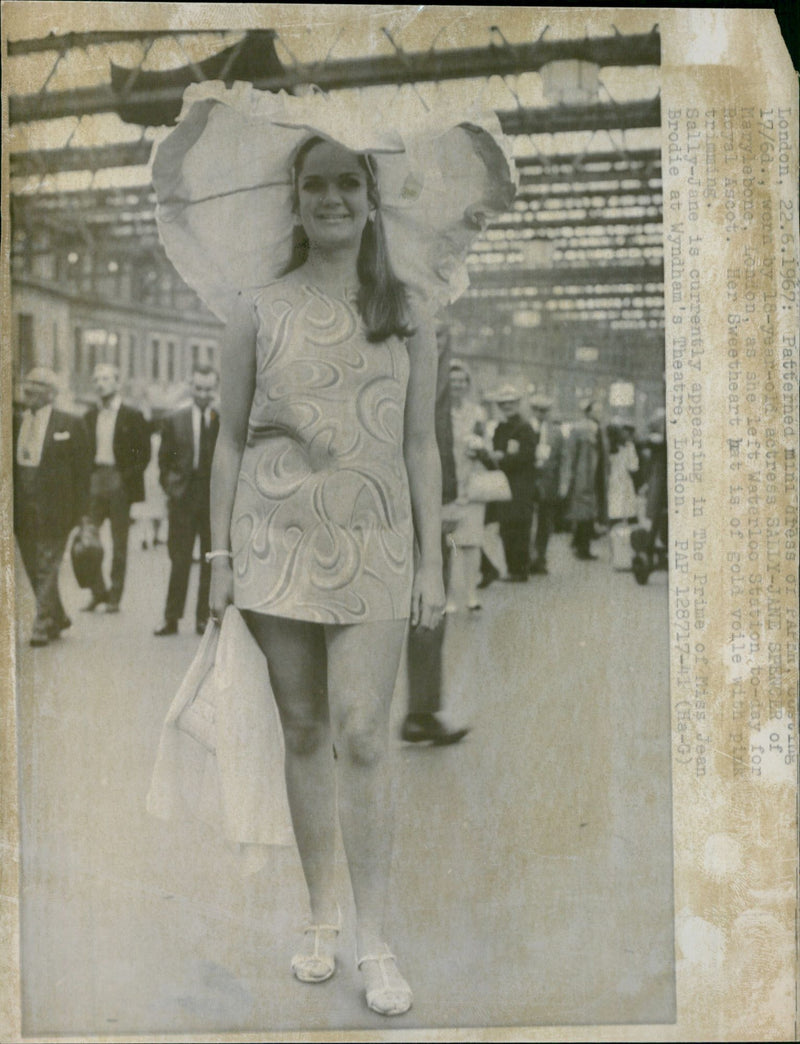 Actress Sally-Jane Spencer of Marylebone, London, leaving Waterloo Station for Royal Ascot, wearing a patterned mini dress of paper and a sweetheart hat of gold voile with pink trimming. - Vintage Photograph