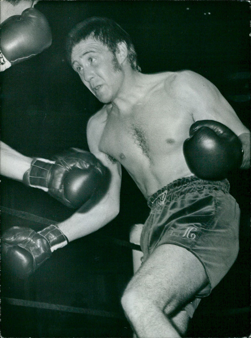 Boxer John Stracey (left) and Grezeni Pis (right) sparring in a boxing ring. - Vintage Photograph