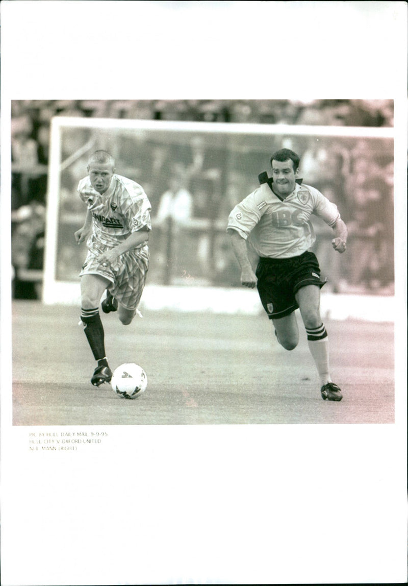 Hull City midfielder Neil Mann (right) competes for the ball against Oxford United defender David Rush (left). - Vintage Photograph